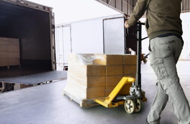 Worker courier unloading cargo pallet shipment goods, package box, his using hand pallet  jack load into a truck, Road freight transport, Warehouse industrial delivery shipment and logistics